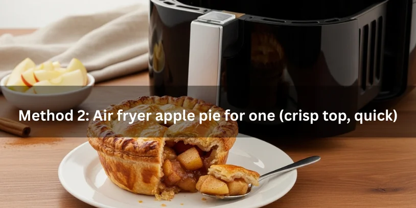 Air fryer apple pie for one in a small ramekin with golden crisp top and tender cinnamon apple filling, shown beside a partially open air fryer basket.-apple pie for one 