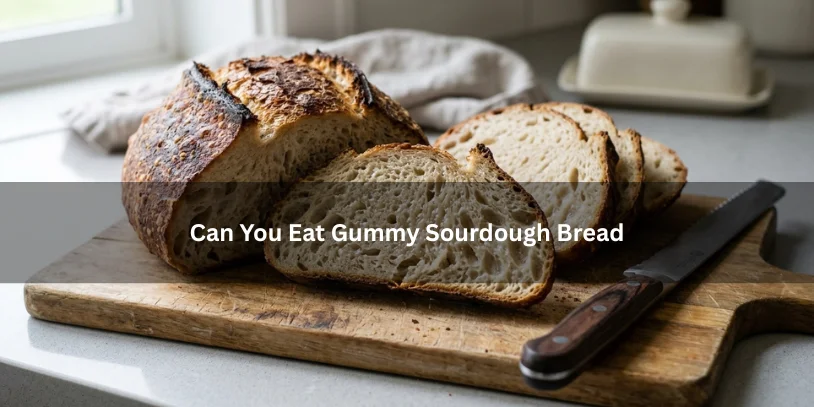 Sliced sourdough bread with a dense, slightly gummy interior crumb on a wooden board, illustrating whether gummy sourdough bread can be eaten.-can you eat gummy sourdough bread