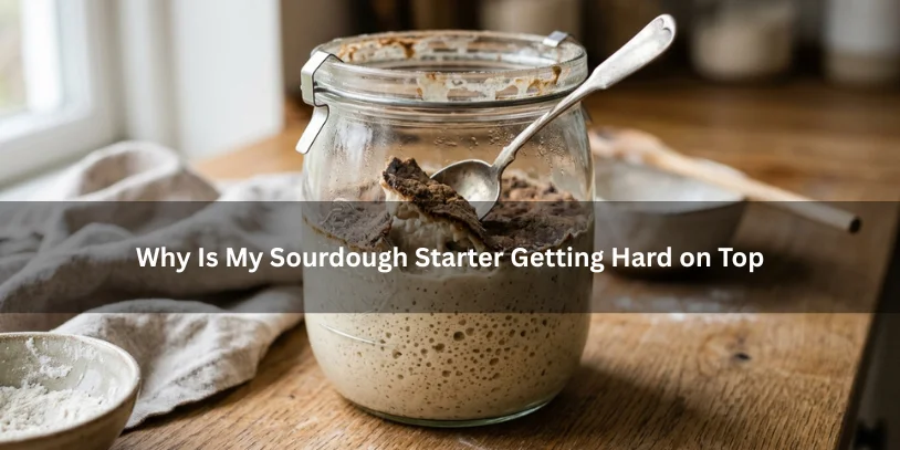 Sourdough starter in a glass jar with a hard dry crust on top and soft starter underneath, illustrating why starter gets hard on top under soft natural lighting.-why is my sourdough starter getting hard on top